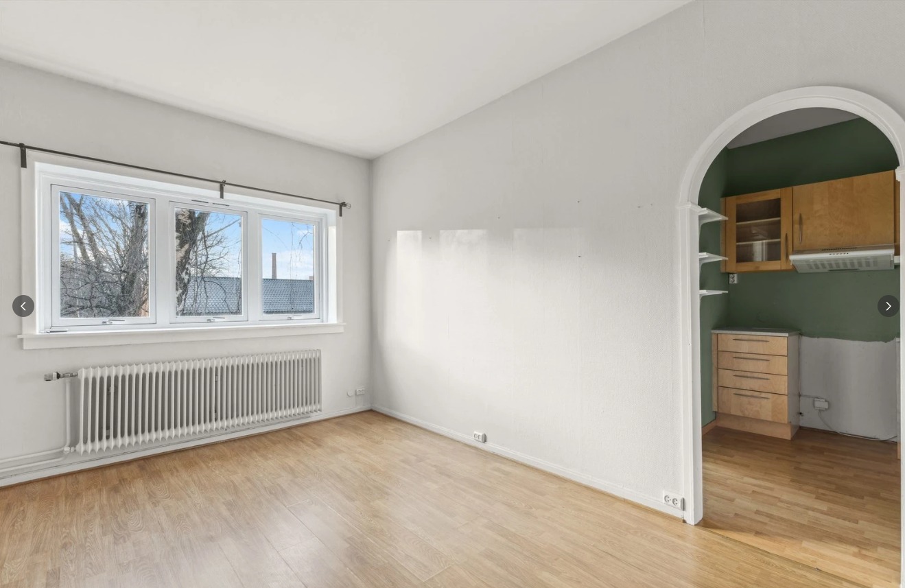 Stor og romslig stue med inngang til kjøkken 